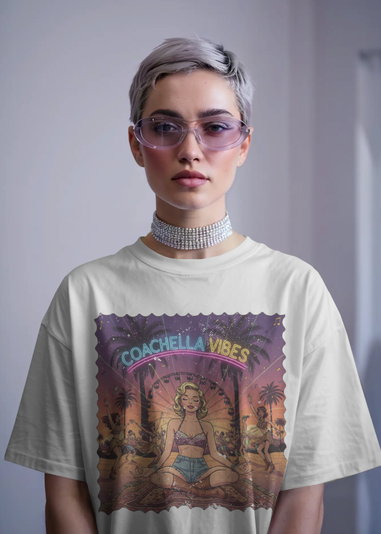 Person wearing a 'Coachella Vibes' t-shirt with a graphic design on a plain background