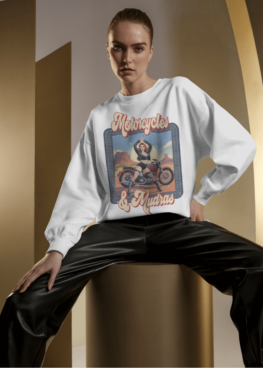 Person wearing a white sweatshirt with graphic design and text, sitting on a chair.
