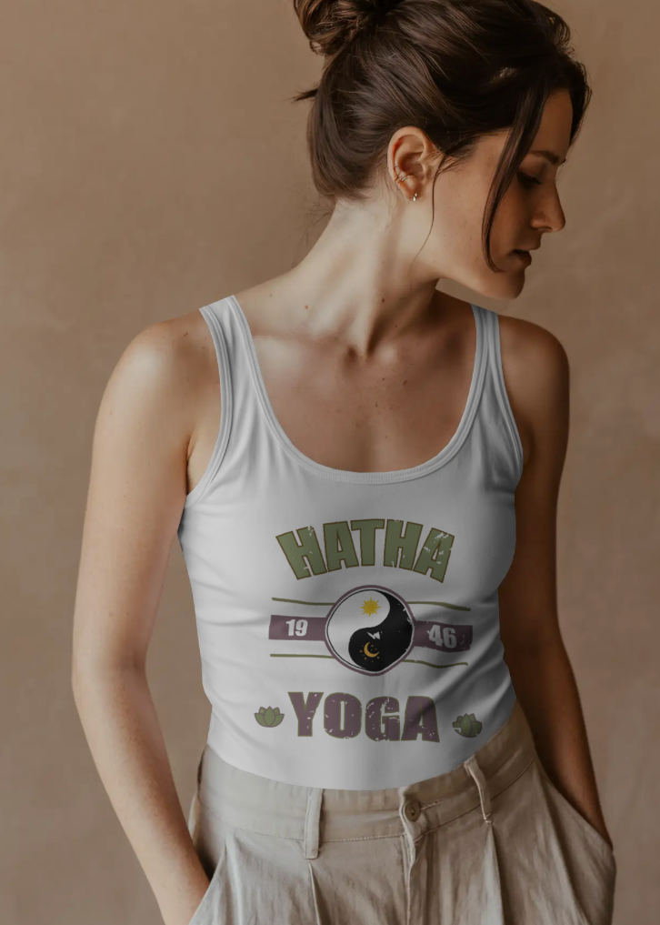 Woman wearing a white tank top with 'Hatha Yoga' design against a beige background