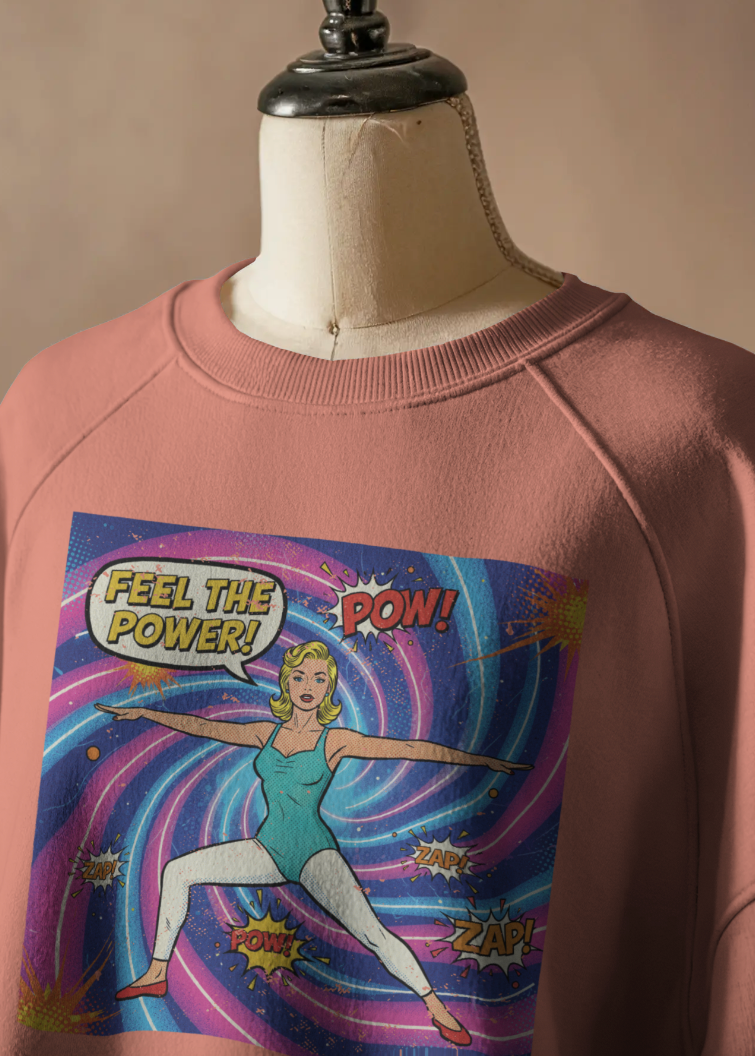 Pink sweatshirt with superhero graphic on a mannequin against a beige background
